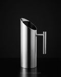 A modern stainless steel pitcher with a tapered, angled pouring spout and a vertical handle, Commercial Stainless Steel Water Pitcher, 1.5 Liter Stainless Beverage Jug, Hotel Room Service Water Jug, Catering Stainless Steel Carafe, Modern Cylinder Beverage Pitcher, Stainless Steel Pitcher with Ice Guard, Commercial Dining Room Water Pitcher, Silver Stainless Steel Serving Jug, Hotel Banquet Water Pitcher, Restaurant Metal Drink Pitcher