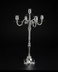 A polished silver candelabra with five arms, featuring ornate sculpted details and a decorative pedestal base,26 Inch Silver Candelabra, 5 Light Metal Candle Stand, Tall Silver Candle Holder USA, Luxury Table Centerpiece Candelabra, Vintage Rococo Silver Candelabra, High End Wedding Centerpiece Stand, Polished Silver Taper Candle Holder, Designer Estate Mantel Decor, Classical European Metal Candle Stand, Elegant Dinner Party Table Accent