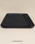 Pack of 6 black non-slip rectangular serving trays for restaurant and bar use.