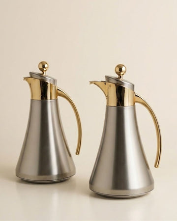 Two stainless steel carafes with polished gold-tone handles, spouts, and lid knobs,
Silver and Gold Coffee Thermos Set of 2, 1 Liter Stainless Thermal Coffee Carafe, Two Tone Metal Beverage Pitcher, Pink Glass Vacuum Flask Set, Luxury Catering Thermal Dispenser, Modern Gold Accent Tea Carafe, Insulated Hot Water Pitcher for Events, Luxury Silver Coffee Server Set, Stainless Steel Catering Thermos USA, Modern Metallic Beverage Carafe for Weddings