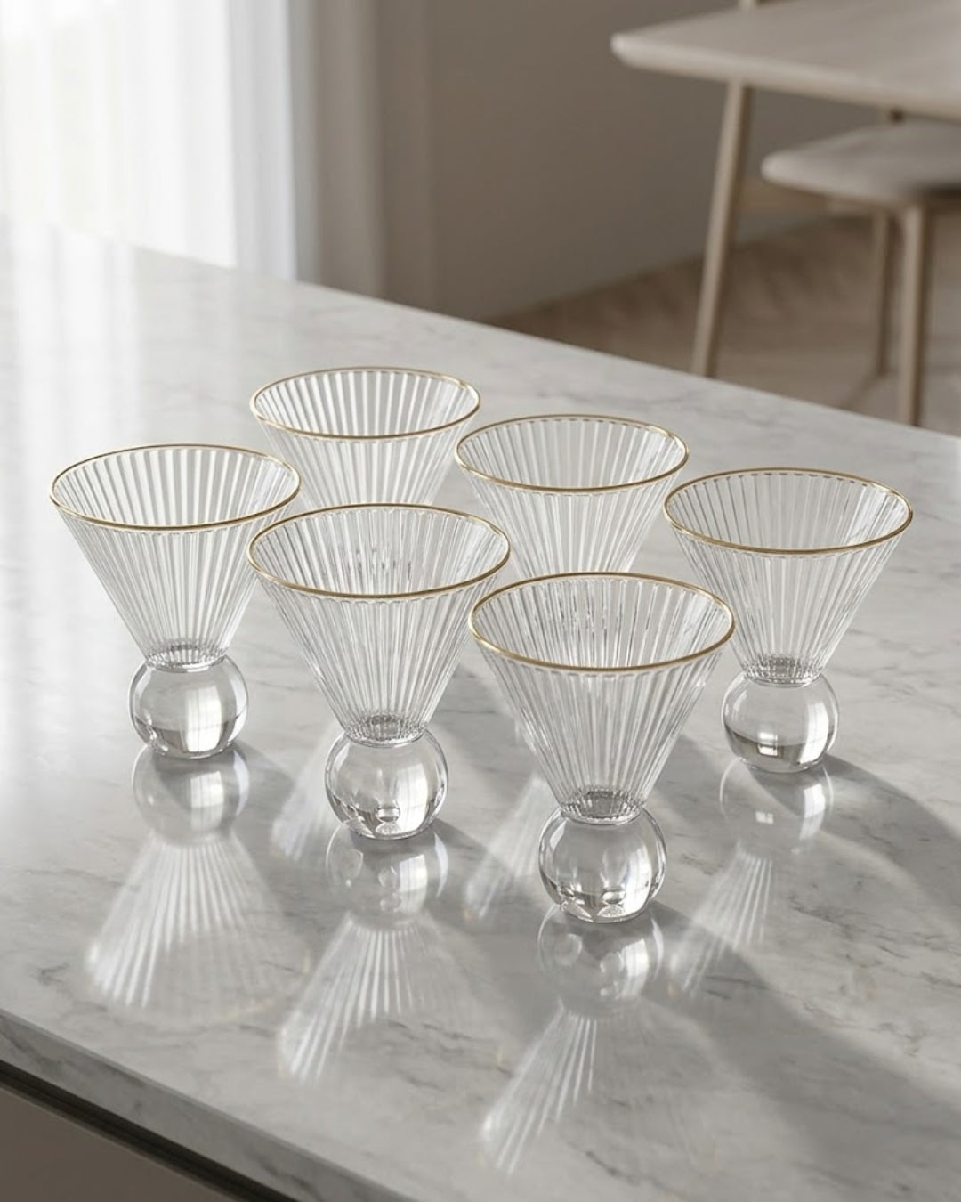 Five clear ribbed glass cocktail glasses with gold rims and clear glass bases, arranged on a light marble countertop in a bright interior setting.
Gold Rim Glass Dessert Bowl Set, Fluted Martini Glasses 7 oz, Ribbed Glass Ice Cream Cup, Gold Rimmed Cocktail Coupe Glass, Ball Base Dessert Glass, Clear Glass Mousse Cup Set of 6, Vintage Style Fluted Barware, Commercial Catering Glassware USA, Heavy Duty Dessert Glasses for Events, Decorative Gold Rimmed Parfait Cup