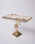 An ornate rectangular serving tray with a clear cut-glass or crystal top and an elaborate gold-tone metal base and trim, photographed against a plain light gray studio background.

Gold Pedestal Glass Serving Tray, Rectangular Glass Centerpiece Bowl, Vintage Gold Raised Dessert Platter, Floral Stem Footed Glass Tray, Luxury Table Centerpiece Dish, Gold Metal and Cut Glass Serving Tray, Decorative Coffee Table Platter, Crystal Gem Floral Serving Dish, High-End Appetizer Display Platter, Antique Style Gold Pe