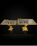 Two ornate rectangular gold and silver trays with sculpted gold pedestal bases, displayed on a reflective black background.