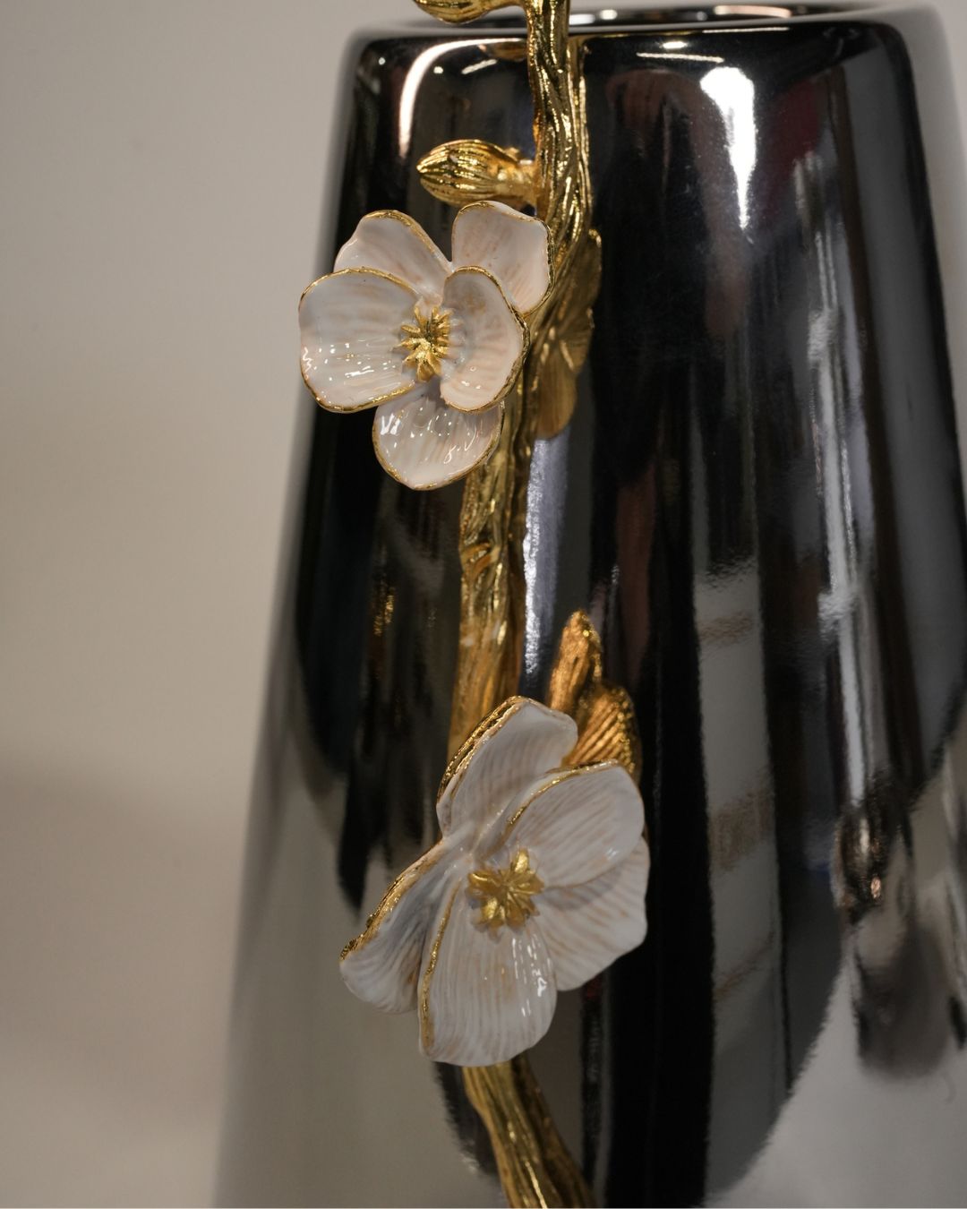 Close-up of a glossy black vase decorated with white enamel flowers and gold-toned stems and leaves, 12 Inch Stainless Steel Vase, Luxury Jasmine Flower Vase, High End Metallic Centerpiece Vase, Botanical Floral Decor Vase for Catering, Modern Silver Tabletop Vase, Premium Event Floral Presentation USA, Designer Metal Console Vessel, Gold and Silver White Flower Vase, Luxury Wedding Centerpiece Vase, Tarnish Resistant Stainless Steel Decor