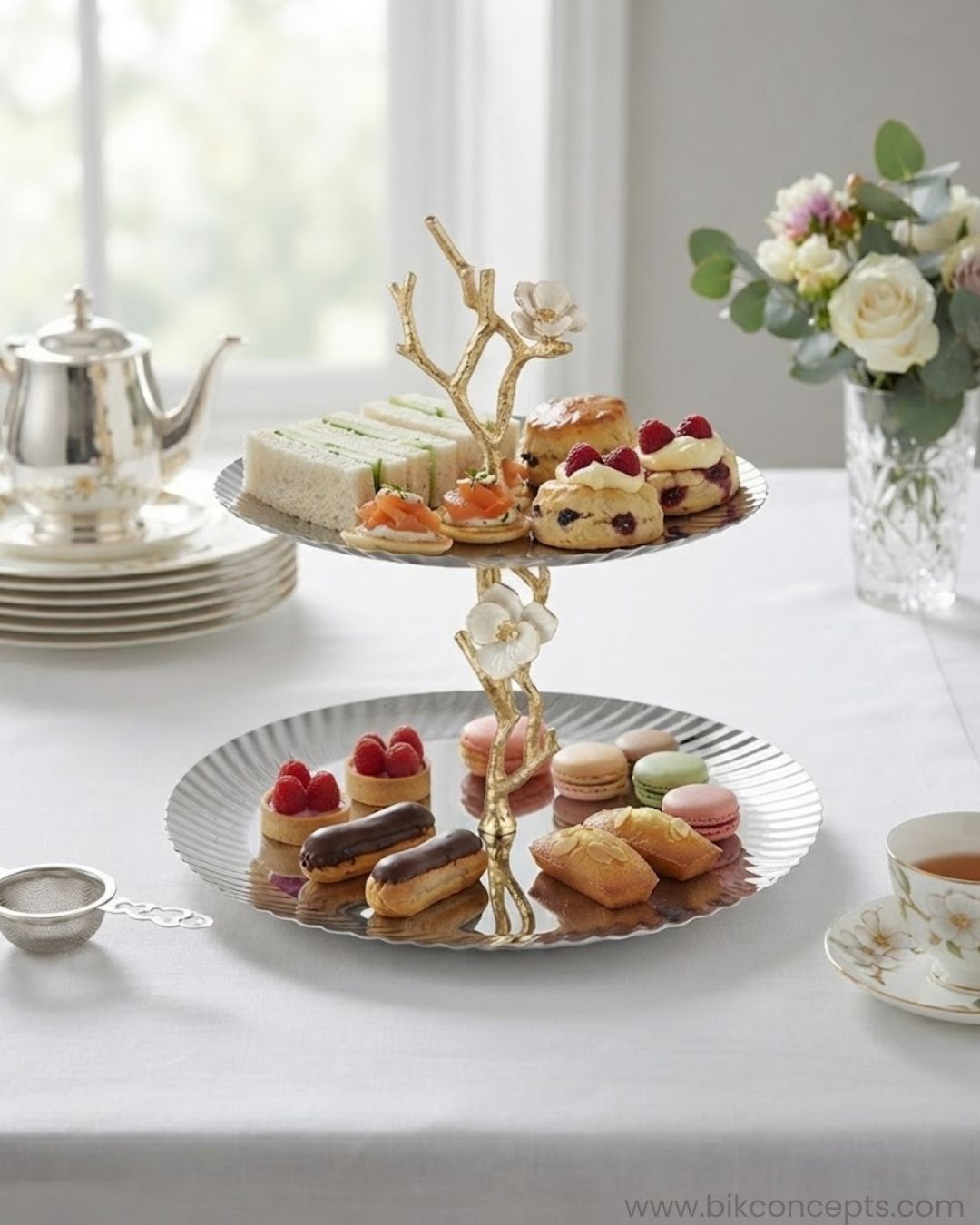 A two-tiered serving stand with scalloped white plates and a gold branch-and-flower central structure, 2 Tier Stainless Steel Platter, Luxury Tiered Dessert Stand, Jasmine Collection Serving Tray, High End Catering Platter USA, Silver Tiered Pastry Stand, Botanical Metal Buffet Display, Gold and Silver Tiered Tray, Designer Afternoon Tea Stand, Luxury Wedding Food Display, Decorative 2 Tier Metal Server