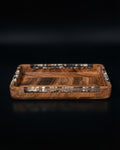A rectangular wooden tray with a rich brown wood grain and decorative inlaid bands of black, white, and brown patterned material around the edges, Wood and Epoxy Resin Serving Tray, Rectangular Solid Wood Serving Tray, Natural Timber Catchall Tray, Nature Enthusiast Home Accessories, Shell Inlaid Resin Platter, Handcrafted Wooden Coffee Tray, Coastal Organic Decor Tray, Slim Rectangular Serving Board, Wooden Vanity Catchall 12x6, Biophilic Home Hosting Decor