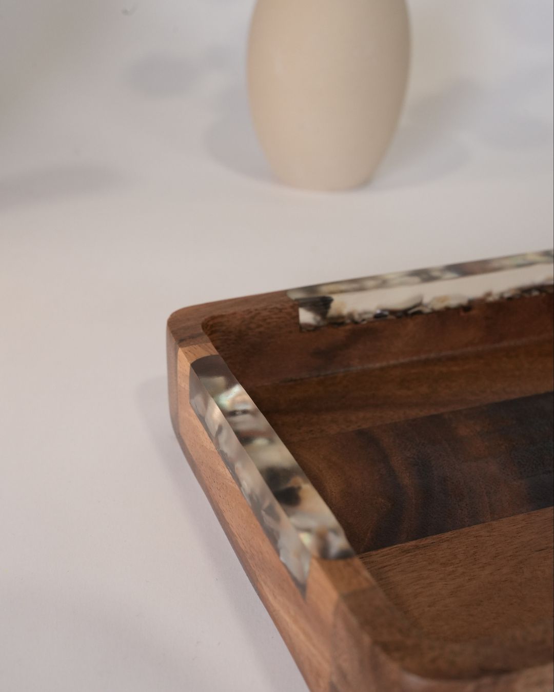 A close-up of a rectangular wooden tray with a dark brown wood grain finish and a tortoiseshell-patterned resin inlay along the rim, Wood and Epoxy Resin Serving Tray, Rectangular Solid Wood Serving Tray, Natural Timber Catchall Tray, Nature Enthusiast Home Accessories, Shell Inlaid Resin Platter, Handcrafted Wooden Coffee Tray, Coastal Organic Decor Tray, Slim Rectangular Serving Board, Wooden Vanity Catchall 12x6, Biophilic Home Hosting Decor