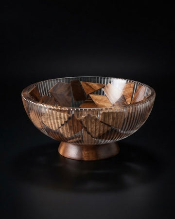 A decorative wooden bowl with a geometric mosaic pattern of interlocking triangular wood pieces and a fluted, ribbed texture, set on a small wooden pedestal, Wood and Epoxy Resin Serving Bowl, Round Wooden Mosaic Serving Bowl, Fluted Resin Fruit Bowl, Nature Enthusiast Home Decor, Footed Resin Timber Bowl, Geometric Wood Mosaic Pedestal Bowl, Organic Modern Kitchen Basin, Handcrafted Wooden Centerpiece Bowl, Artisanal Ribbed Glass Look Bowl, Biophilic Home Accessories
