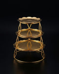A three-tiered gold metal serving stand with scalloped edges on each tray, Golden Metal Buffet Risers, Round Food Presentation Risers, Floral Scalloped Cake Pedestal, Nature Enthusiast Party Decor, Gold Tiered Dessert Stand, Separable Plate Buffet Display, Botanical Golden Serving Risers, Metal Tabletop Riser Set, Nesting Food Display Pedestals, Elevated Charcuterie Stand Gold
