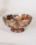 A decorative wooden bowl with a geometric mosaic pattern of interlocking wood pieces in various shades of brown and beige, set on a matching wooden pedestal base, Wood and Epoxy Resin Serving Bowl, Round Wooden Mosaic Serving Bowl, Fluted Resin Fruit Bowl, Nature Enthusiast Home Decor, Footed Resin Timber Bowl, Geometric Wood Mosaic Pedestal Bowl, Organic Modern Kitchen Basin, Handcrafted Wooden Centerpiece Bowl, Artisanal Ribbed Glass Look Bowl, Biophilic Home Accessories