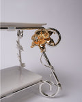 A close-up of an ornate two-tier display stand with a polished silver metal frame featuring a decorative gold flower accent with a clear rhinestone, holding white rectangular plates.

Silver 2 Tier Serving Stand, Two Tier Ceramic Dessert Stand, High End Catering Dessert Tray, Botanical Bird Food Stand, Rectangular Ceramic Serving Rack, Luxury Party Dessert Display, Silver Metal Tiered Pastry Stand, Upscale Wedding Dessert Tower, Two Tone Buffet Serving Rack, Double Layer Macaron Stand, Gold and Silver Tiere