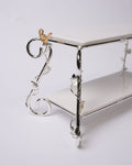 A two-tiered white ceramic shelf with an ornate silver metal frame featuring vine and leaf details, a small gold bird accent on the top corner, and a white background.

Silver 2 Tier Serving Stand, Two Tier Ceramic Dessert Stand, High End Catering Dessert Tray, Botanical Bird Food Stand, Rectangular Ceramic Serving Rack, Luxury Party Dessert Display, Silver Metal Tiered Pastry Stand, Upscale Wedding Dessert Tower, Two Tone Buffet Serving Rack, Double Layer Macaron Stand, Gold and Silver Tiered Tray