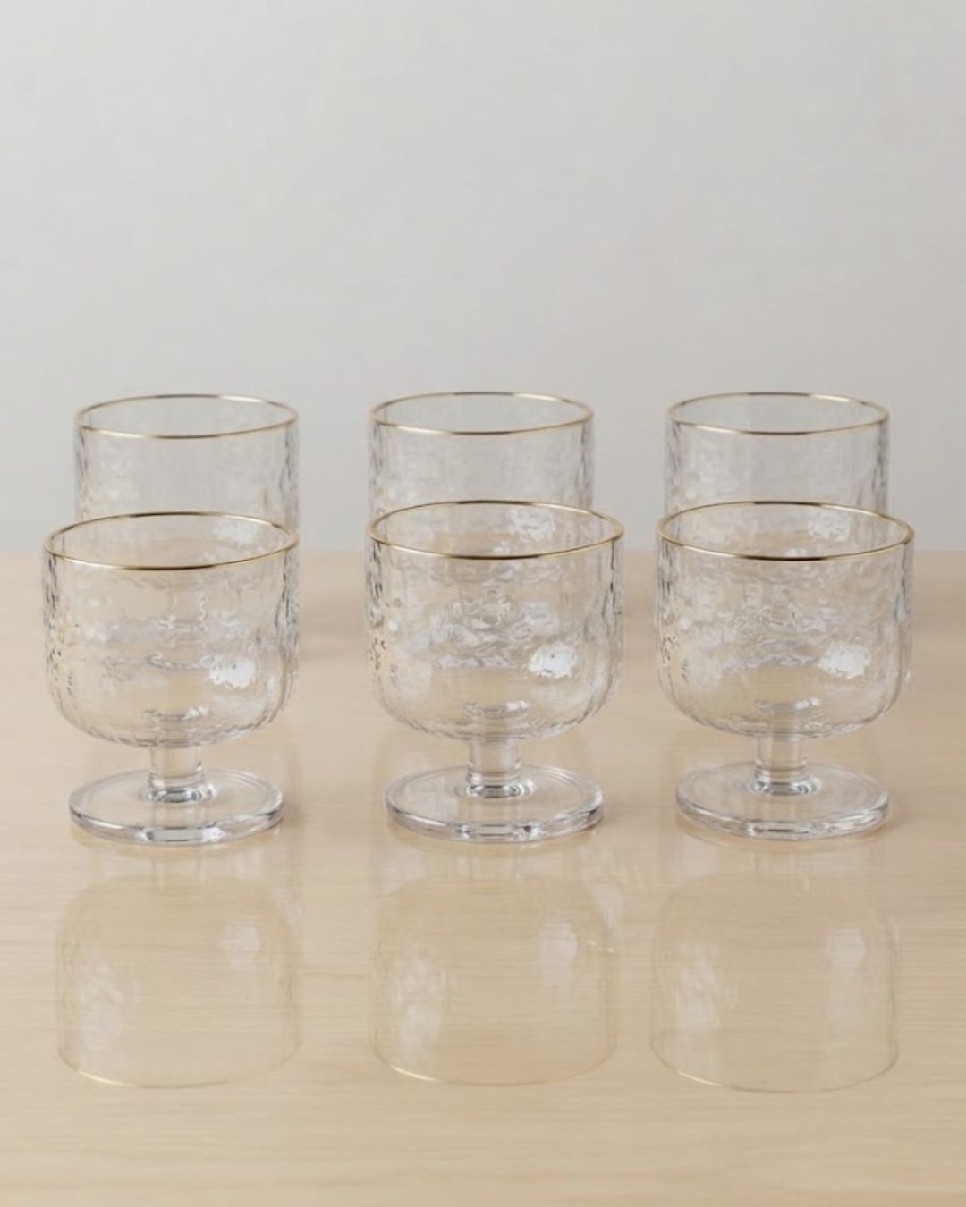 Six clear glass goblets with a textured pattern and gold rim, arranged in two rows on a light wooden surface against a neutral off-white background,

Textured Glass Dessert Bowls, 5.5 oz Ice Cream Cups Set of 6, Footed Sundae Dishes, Gold Rim Parfait Glasses, Hammered Glass Dessert Cups, Mini Trifle Dishes for Catering, Commercial Catering Glassware USA, Clear Footed Sorbet Cups, Vintage Style Ripple Sundae Glass, Heavy Duty Mini Dessert Glasses