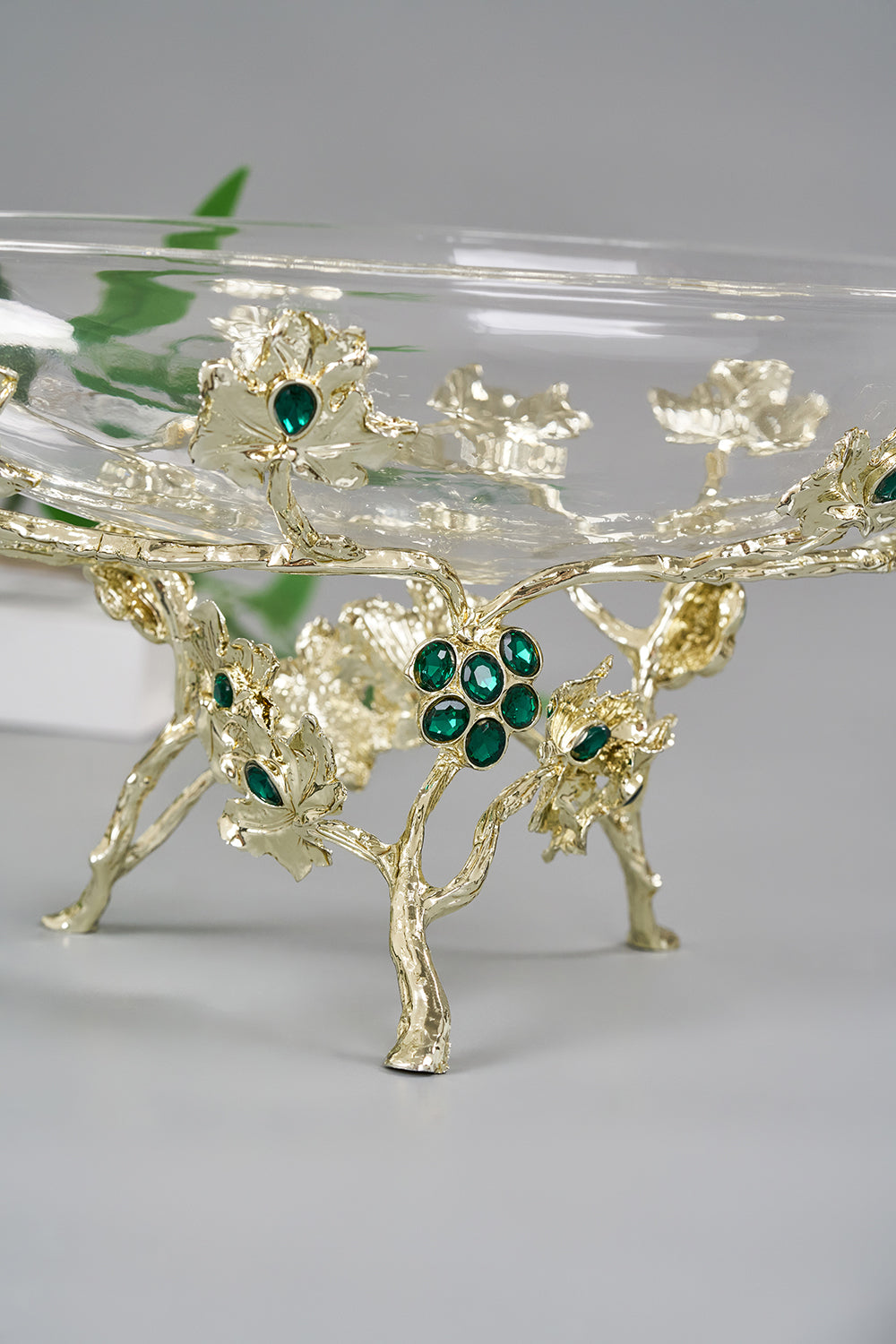 luxury emerald glass serving dish, clear glass platter silver leaf stand, jewel accented crystal dessert tray, emerald green stone decorative bowl, bik concepts emerald collection, premium silver vine glass centerpiece, elegant jewel toned party platter, high end glass fruit bowl centerpiece, luxury host housewarming gift dish, sophisticated 12 inch glass serveware, regal silver and green display bowl, clear glass bowl with artistic pedestal, heirloom quality holiday serving platter